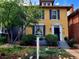 Lovely yellow two-story home with black shutters and a well-manicured, inviting front yard at 263 N Logan St, Denver, CO 80203