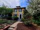 Charming two-story yellow home with black shutters and landscaped front yard at 263 N Logan St, Denver, CO 80203