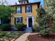 Beautiful two-story home featuring a yellow exterior, black shutters, and a landscaped front yard at 263 N Logan St, Denver, CO 80203