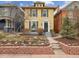 Charming two-story yellow home with a brick garden and a welcoming front entrance at 263 N Logan St, Denver, CO 80203