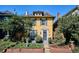 Charming two-story yellow home with a landscaped front yard and inviting entryway at 263 N Logan St, Denver, CO 80203