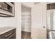 Walk-in pantry adjacent to the kitchen with wire shelves, wood-look floors, and a door at 13725 Daffodil Pt, Parker, CO 80134