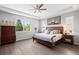 Serene primary bedroom features a tray ceiling, a ceiling fan, and lots of windows for natural light at 3575 White Rose Loop, Castle Rock, CO 80108