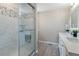 Contemporary bathroom featuring a glass-enclosed shower with decorative tile and double sink vanity at 1535 Peach Ct, Brighton, CO 80601