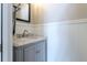 Stylish half bathroom with decorative wainscotting and marble topped vanity at 1535 Peach Ct, Brighton, CO 80601