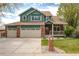 Charming two-story home featuring a well-manicured lawn, front porch, and three-car garage at 1535 Peach Ct, Brighton, CO 80601