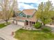 Well-manicured lawn and mature trees enhance this two-story home with a three-car garage at 1535 Peach Ct, Brighton, CO 80601