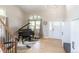Grand foyer featuring hardwood floors, a black piano, and a front door with glass details at 1535 Peach Ct, Brighton, CO 80601