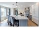 Modern kitchen with white cabinets, quartz countertops, large island, and stainless steel appliances at 1535 Peach Ct, Brighton, CO 80601