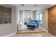Cozy sitting area featuring a custom built-in shelving and brick accent wall at 1535 Peach Ct, Brighton, CO 80601