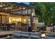 A backyard patio with a pergola, dining area, fire pit, and contemporary fountain features at 4181 S Ivy Ln, Cherry Hills Village, CO 80111