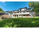 Expansive backyard featuring lush lawn, stone terraces, outdoor kitchen, and multi-level patio at 4181 S Ivy Ln, Cherry Hills Village, CO 80111