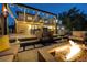 An outdoor patio features a stone fountain, fire pit, pergola and cafe lights for modern entertaining at 4181 S Ivy Ln, Cherry Hills Village, CO 80111