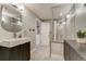 Modern bathroom featuring gray tile, glass enclosed shower, floating vanity with sleek sink and fixtures at 4181 S Ivy Ln, Cherry Hills Village, CO 80111