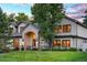 Beautiful home with manicured lawn, brick accents, an arched entry, and a well-maintained landscape at 4181 S Ivy Ln, Cherry Hills Village, CO 80111