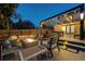Outdoor patio with comfortable seating, a fire pit, and overhead lighting, creating a cozy evening ambiance at 4181 S Ivy Ln, Cherry Hills Village, CO 80111