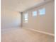 Bright bedroom with neutral walls and carpet features three windows that provide plenty of natural light at 4769 Weitbrec Ln, Castle Rock, CO 80104