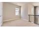 Upstairs bedroom with natural light, light neutral walls and carpet, and black iron railing at 4769 Weitbrec Ln, Castle Rock, CO 80104
