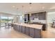 Modern kitchen featuring a central island with a sink, dark wood cabinets, and an adjacent dining area with natural light at 4769 Weitbrec Ln, Castle Rock, CO 80104