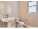 Neat powder room features a white pedestal sink, an oval mirror, and a window with natural light at 4769 Weitbrec Ln, Castle Rock, CO 80104