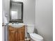 Small bathroom with wood vanity, toilet, and framed mirror with overhead lighting at 1482 S Pierson St # 75, Lakewood, CO 80232