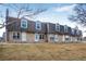 A row of brick townhomes with well-maintained lawns and gable roofs under a blue sky at 1482 S Pierson St # 75, Lakewood, CO 80232