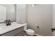 Modern half bath with a gray vanity, white quartz countertop, matte black fixtures, and a white toilet at 9454 Yampa St, Commerce City, CO 80022
