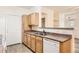 Well-lit kitchen with classic wood cabinetry, essential appliances, and a convenient breakfast bar, blending style and practicality at 8481 W Union Ave # 2-103, Littleton, CO 80123