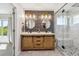 Beautiful bathroom featuring a double vanity, striking brick backsplash, and walk-in glass shower at 12277 Krameria St, Brighton, CO 80602