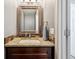 Powder room featuring granite countertops, tile backsplash and wood cabinets at 12277 Krameria St, Brighton, CO 80602