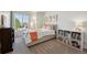 Bright bedroom with a large window, a comfortable bed, and shelving for storage and display at 12277 Krameria St, Brighton, CO 80602