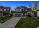 Charming two-story home with a well-maintained lawn and a driveway leading to an attached two-car garage at 12277 Krameria St, Brighton, CO 80602