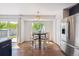 Bright kitchen area with stainless steel refrigerator and a dining table set near a sliding glass door at 12277 Krameria St, Brighton, CO 80602