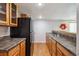 Kitchenette with black refrigerator, warm wood cabinets, and ample countertop space at 12277 Krameria St, Brighton, CO 80602