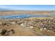 A picturesque aerial view of a neighborhood near a tranquil frozen lake with beautiful skyline views at 8280 E 104Th Way, Henderson, CO 80640