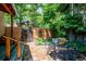 Charming backyard patio features a brick ground cover, metal table with seating, and lush green foliage at 807 9Th St, Golden, CO 80401