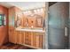 Bathroom featuring wood cabinets, dual sinks, tiled countertop and a textured glass enclosed shower at 807 9Th St, Golden, CO 80401