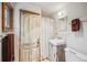 Quaint bathroom featuring a vintage door, modern sink and fixtures, and neutral tones for a clean aesthetic at 807 9Th St, Golden, CO 80401