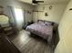 Cozy bedroom featuring wood floors, ceiling fan and barn door closet at 1489 Arapahoe St, Strasburg, CO 80136