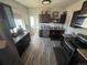 Updated kitchen with dark cabinets, granite countertops, and stainless steel appliances at 1489 Arapahoe St, Strasburg, CO 80136