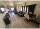 Cozy living room with a sofa, dining table, wood-look flooring, and TV at 1489 Arapahoe St, Strasburg, CO 80136