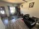 Living room showcasing wood-look floors, a comfortable recliner, and natural light from the window at 1489 Arapahoe St, Strasburg, CO 80136