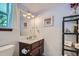 Powder room with a dark vanity, decorative mirror, and tiled walls providing a cozy and practical space at 6311 Xavier St, Arvada, CO 80003