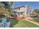 Exterior showcasing a deck, patio, lush lawn, and mature trees at 6311 Xavier St, Arvada, CO 80003
