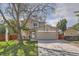 Charming two-story home with mature tree, brick accents, and a well-maintained front yard at 6311 Xavier St, Arvada, CO 80003