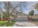 Charming two-story home with mature tree, brick accents, and a well-maintained front yard at 6311 Xavier St, Arvada, CO 80003