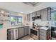 Charming kitchen features stainless appliances, gray cabinets, white tile backsplash, and modern countertop at 6311 Xavier St, Arvada, CO 80003