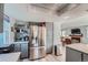 Bright kitchen features gray cabinets, stainless steel refrigerator, and open shelving at 6311 Xavier St, Arvada, CO 80003