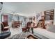 Open-concept living room boasts wood floors, a modern staircase, and an inviting armchair near the kitchen at 6311 Xavier St, Arvada, CO 80003