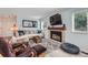 Inviting living room featuring a brick fireplace, neutral-toned furniture, and ample natural light at 6311 Xavier St, Arvada, CO 80003